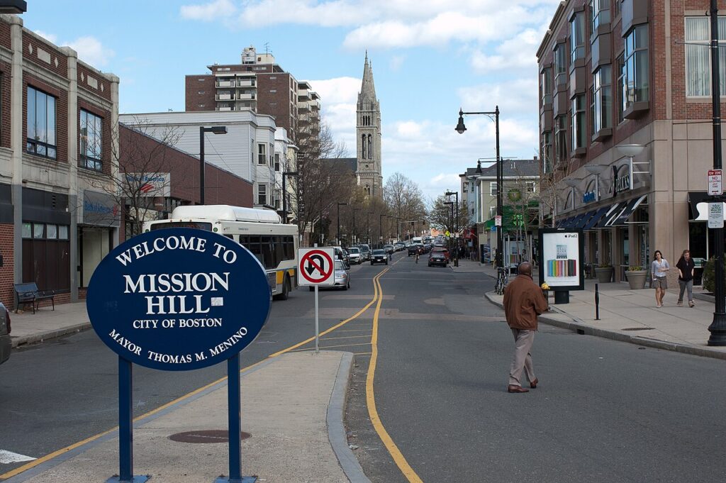 Welcome to Mission Hill sign on Tremont Street in Boston, with the Mission Church spire in the distance — the neighborhood home of Diablo Glass School