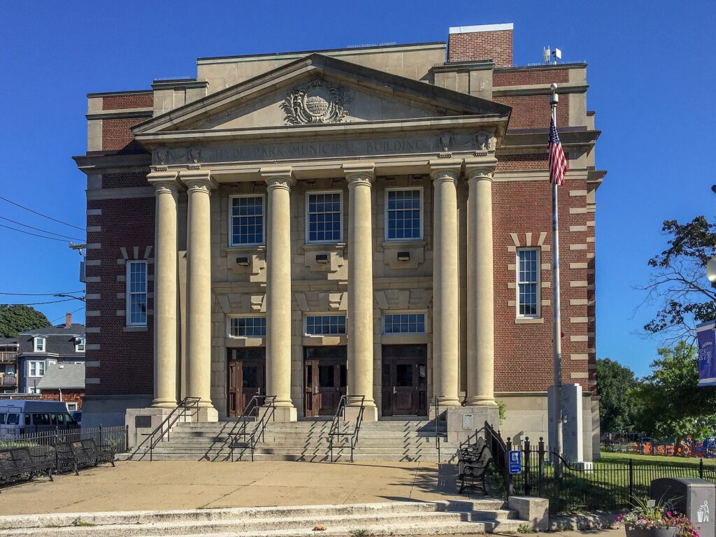 The columned Hyde Park Municipal Building on River Street under a blue sky
