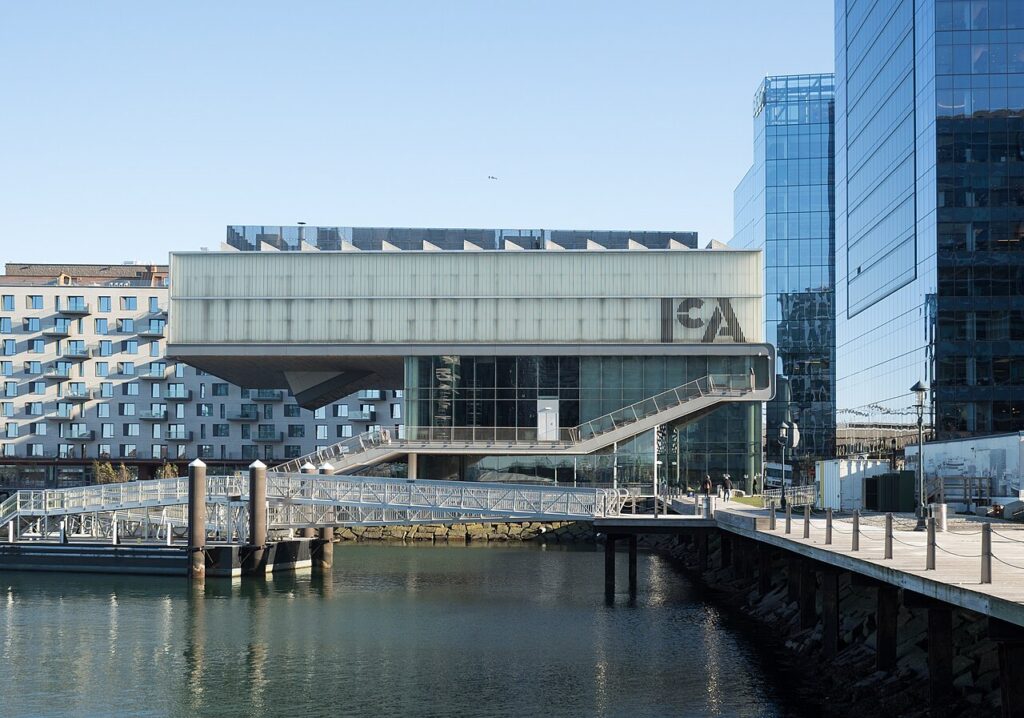 The cantilevered glass-and-steel Institute of Contemporary Art building on the Boston Seaport waterfront, seen from across the water on a clear day