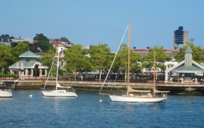 Sailboats moored off the Piers Park waterfront promenade and pavilions along the East Boston Harborwalk on a sunny day